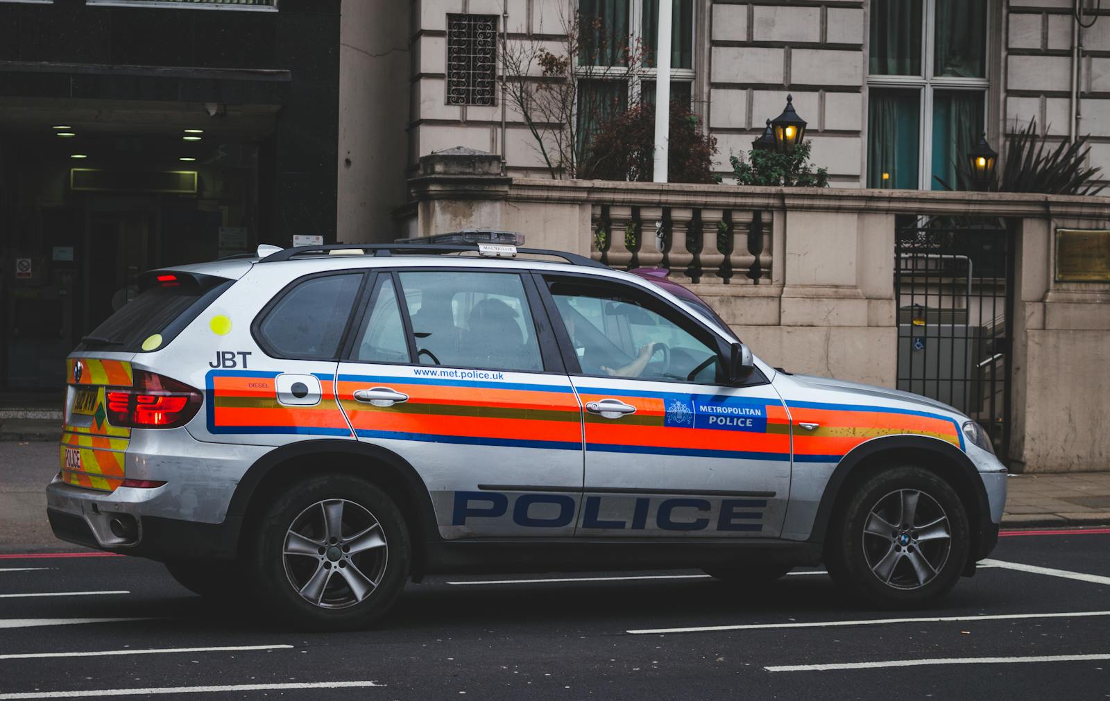 Police vehicle parked on an urban street outside a London building