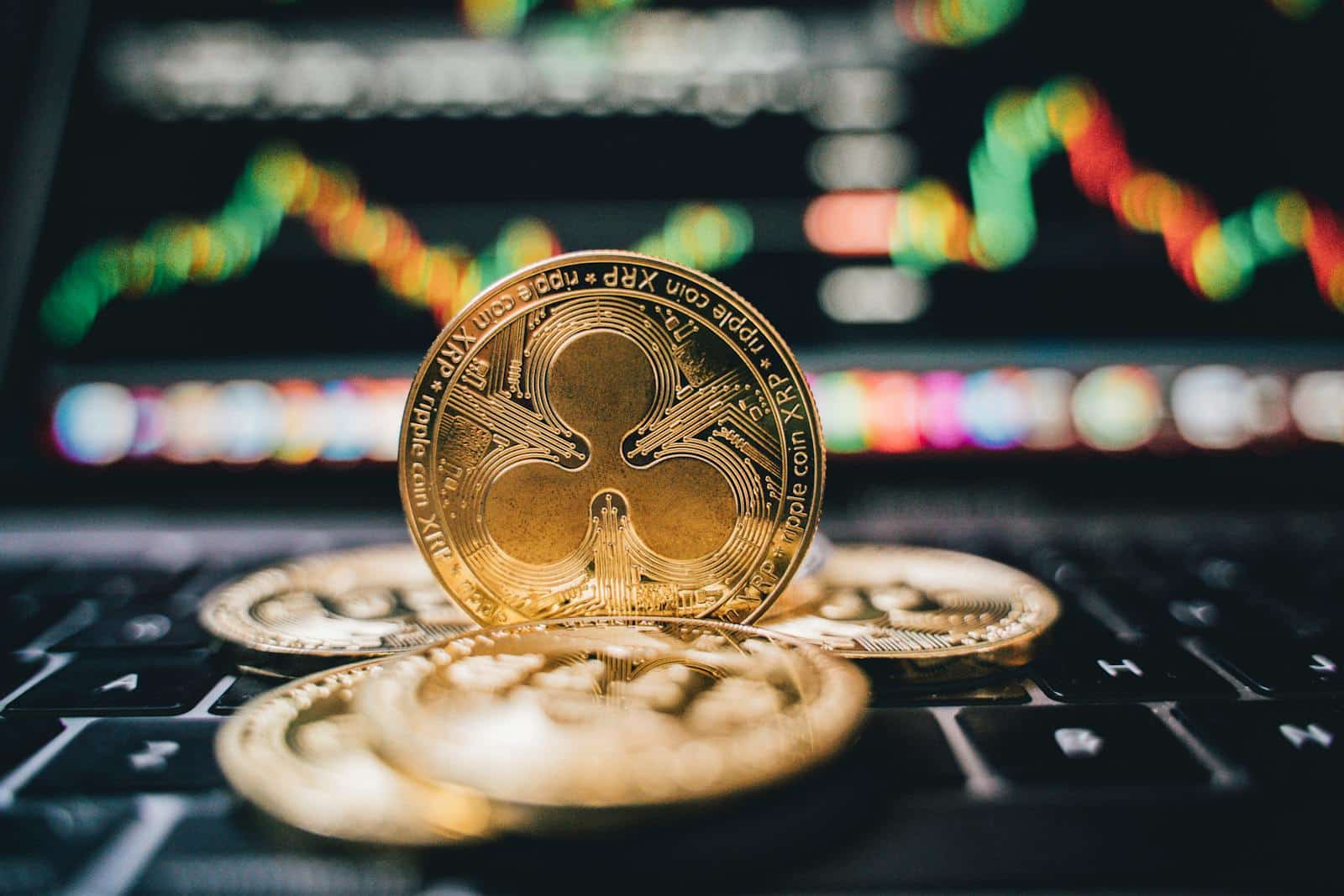 Golden Ripple XRP coins on laptop, symbolizing cryptocurrency trends and online trading.