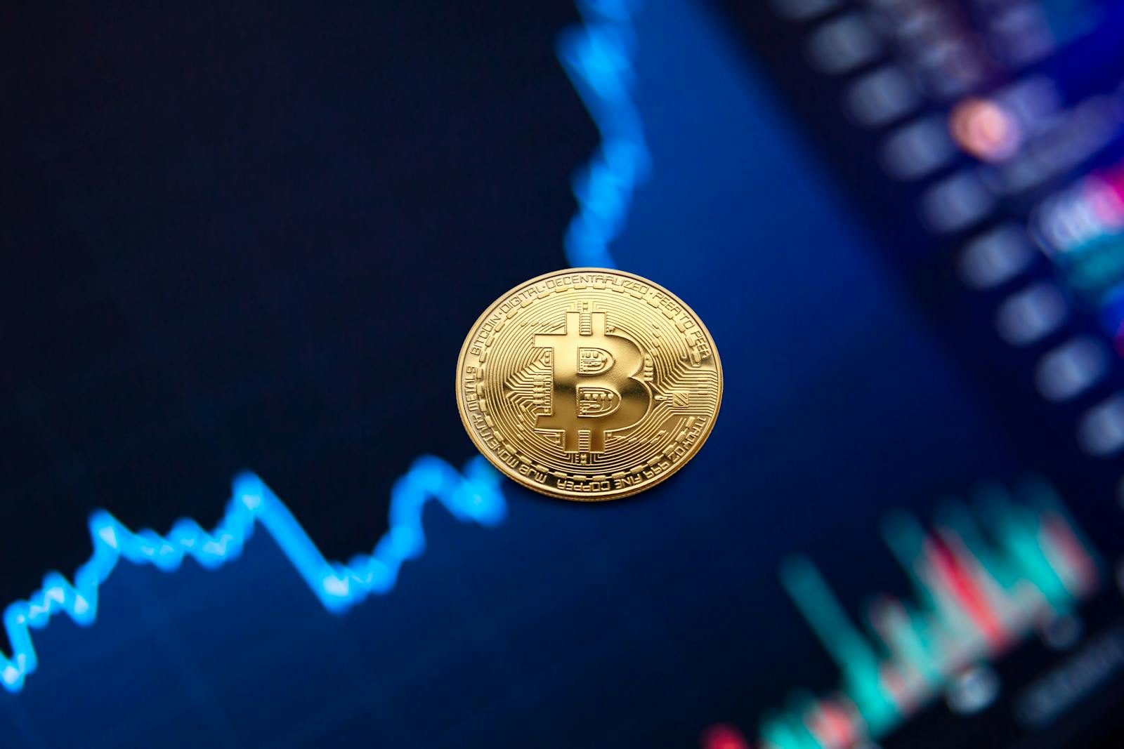 A gold Bitcoin coin against a backdrop of a digital financial chart, symbolizing cryptocurrency trading.